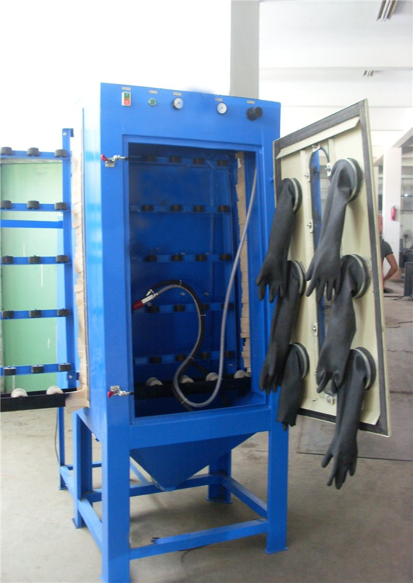 Blast cabinet door open showing the hand gun and the operator gloves